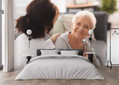 Young doctor visiting elderly woman at home Wall mural