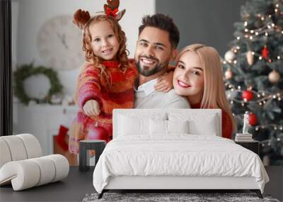 Young family at home on Christmas eve Wall mural