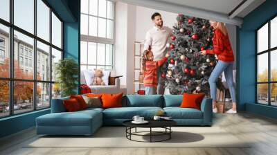 Young family decorating Christmas tree at home Wall mural