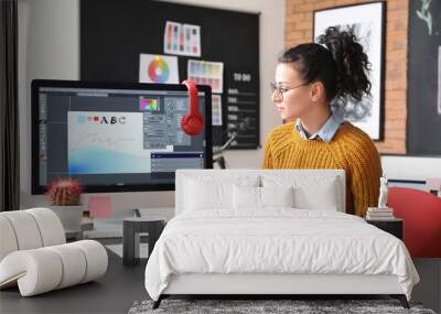 Young female designer working in office Wall mural