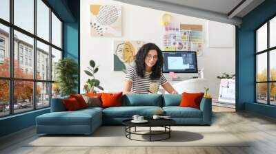 Young female designer working in office Wall mural