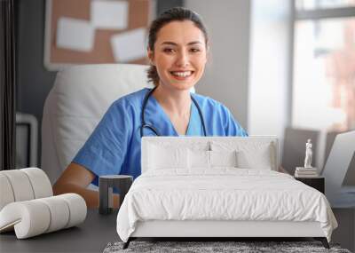 Young female doctor working in clinic Wall mural