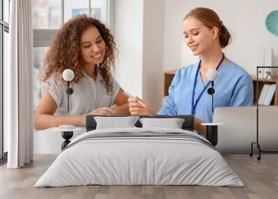 Young female receptionist working with patient in clinic Wall mural