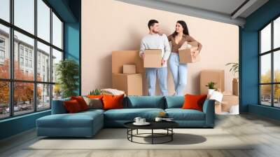 Young happy couple with belongings in their new house Wall mural