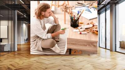 Young male artist painting at home Wall mural