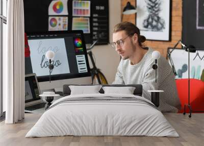 Young male designer working in office Wall mural