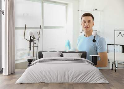 Young male physiotherapist in rehabilitation center Wall mural