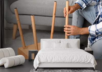 Young man assembling wooden table at home, closeup Wall mural