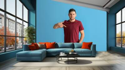 Young man in stylish t-shirt on color background Wall mural