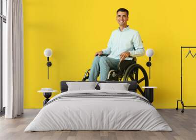 Young man in wheelchair on color background Wall mural