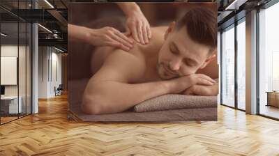 Young man receiving massage at spa salon Wall mural