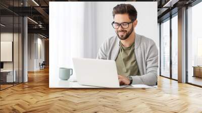 Young man using laptop for online learning at home Wall mural