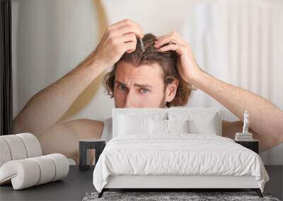 Young man using serum for hair growth in bathroom Wall mural