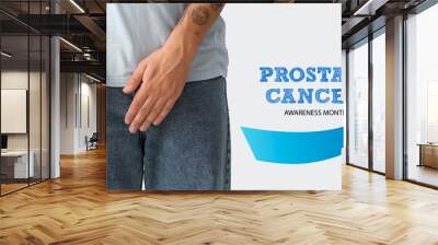 Young man with blue ribbon on light background, closeup. Prostate Cancer Awareness Month Wall mural