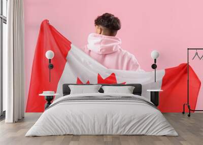 Young man with flag of Canada on pink background Wall mural