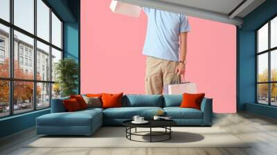 Young man with shopping bags on pink background Wall mural