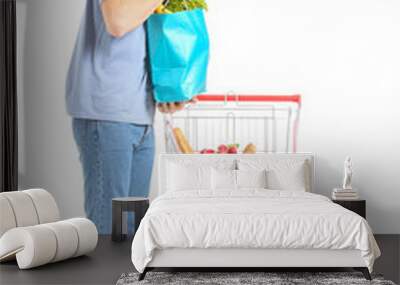 Young man with shopping cart on white background Wall mural