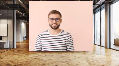 Young man with stylish eyeglasses on color background Wall mural