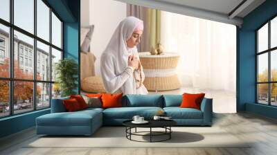 Young Muslim woman praying at home Wall mural