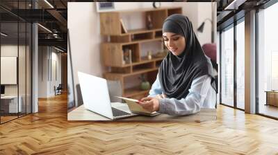 Young Muslim woman working in office Wall mural