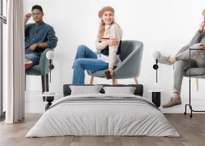 Young people relaxing in armchairs on white background Wall mural