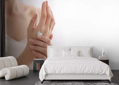 Young woman applying natural cream onto skin at home Wall mural