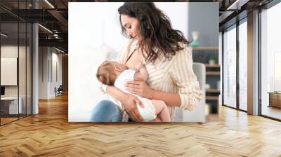 Young woman breastfeeding her baby at home Wall mural