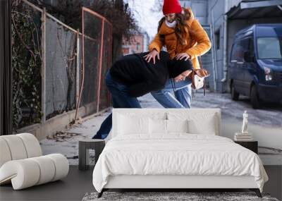 Young woman defending herself from thief outdoors Wall mural