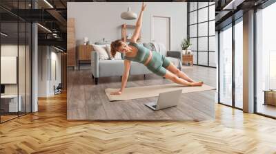 Young woman doing yoga at home Wall mural