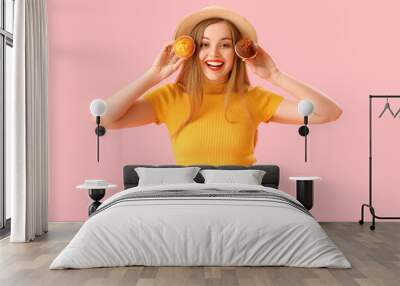 Young woman in hat with tasty muffins on pink background Wall mural