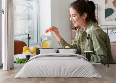 Young woman making fresh lemonade at home Wall mural