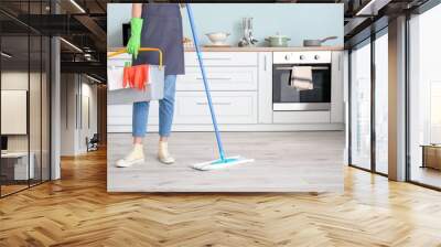 Young woman mopping floor in kitchen Wall mural