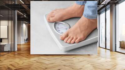 Young woman standing on scales at home, closeup. Weight loss concept Wall mural