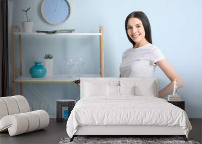 Young woman taking measures of rack in room Wall mural