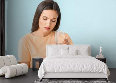 Young woman taking medicine on color background Wall mural