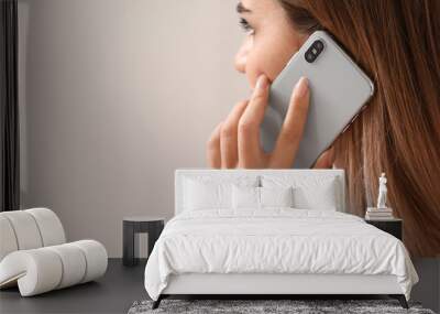 Young woman talking by mobile phone in bedroom Wall mural