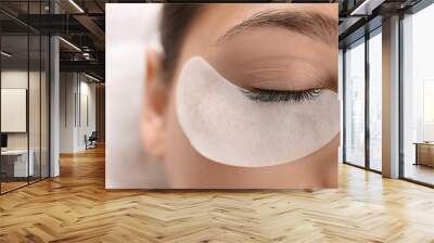 Young woman undergoing eyelash extension procedure in beauty salon, closeup Wall mural