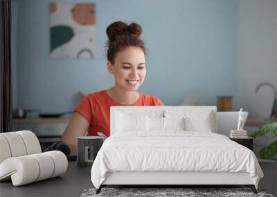 Young woman using laptop for online learning at home Wall mural