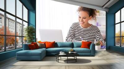 Young woman using laptop for online learning at home Wall mural