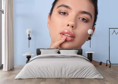 Young woman with beautiful lips on blue background, closeup Wall mural