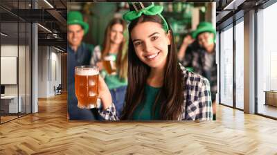 Young woman with beer celebrating St. Patrick's Day in pub Wall mural