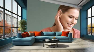 Young woman with hearing on grey background Wall mural