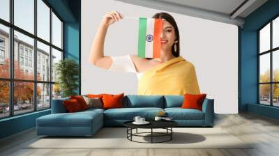 Young woman with Indian flag on light background Wall mural