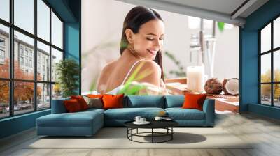 Young woman with jar of coconut oil washing her hair in bathroom Wall mural