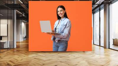 Young woman with laptop on color background Wall mural