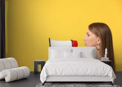 Young woman with megaphone on color background Wall mural