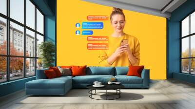 Young woman with mobile phone chatting online on yellow background Wall mural