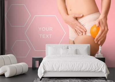 Young woman with orange fruit on color background with space for text. Concept of cellulite Wall mural