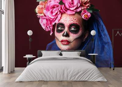 Young woman with painted skull on her face for Mexico's Day of the Dead against color background Wall mural