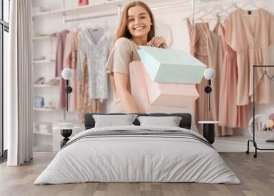 Young woman with shopping bags in boutique Wall mural